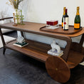 Load image into Gallery viewer, Wooden bar cart console table with decorative items including bottles and a vase on a dark floor.