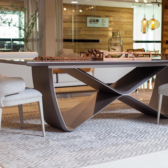 A modern dining table with a unique infinity symbol shaped base and a glass tabletop.