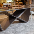 Load image into Gallery viewer, A modern dining table with a unique infinity symbol shaped base and a glass tabletop.