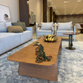 Load image into Gallery viewer, A modern wooden coffee table with a curved, continuous form, crafted from high-quality wood.
