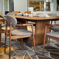 Load image into Gallery viewer, A contemporary dining table with a curved wooden base and a rectangular tabletop.