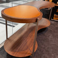 Charger l'image dans la visionneuse de la galerie, Wooden side table with a curved design in a modern interior setting