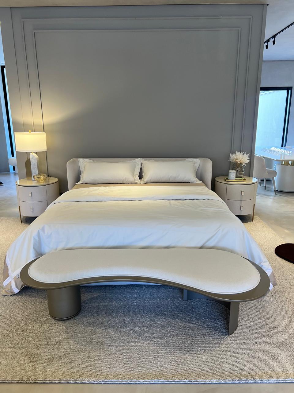 Modern bedroom with a bed, nightstands, and a bench.