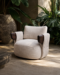 Charger l'image dans la visionneuse de la galerie, Beige armchair with brown armrests in a room with plants and stone walls