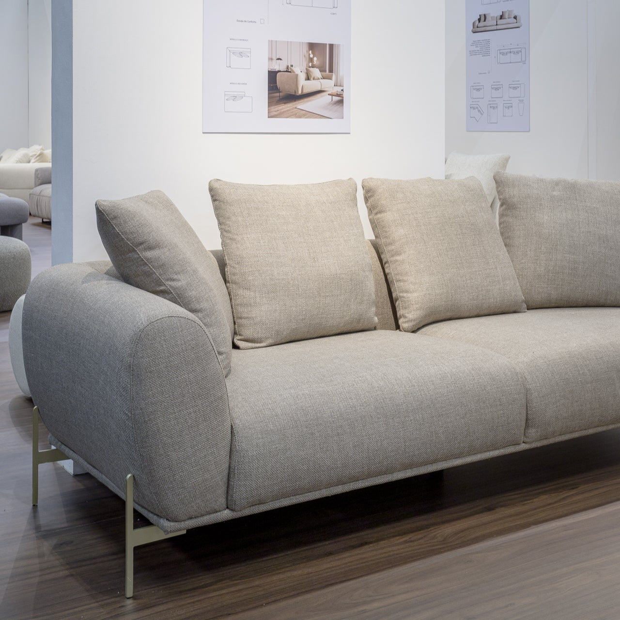 Gray sofa in a showroom with posters on the wall.