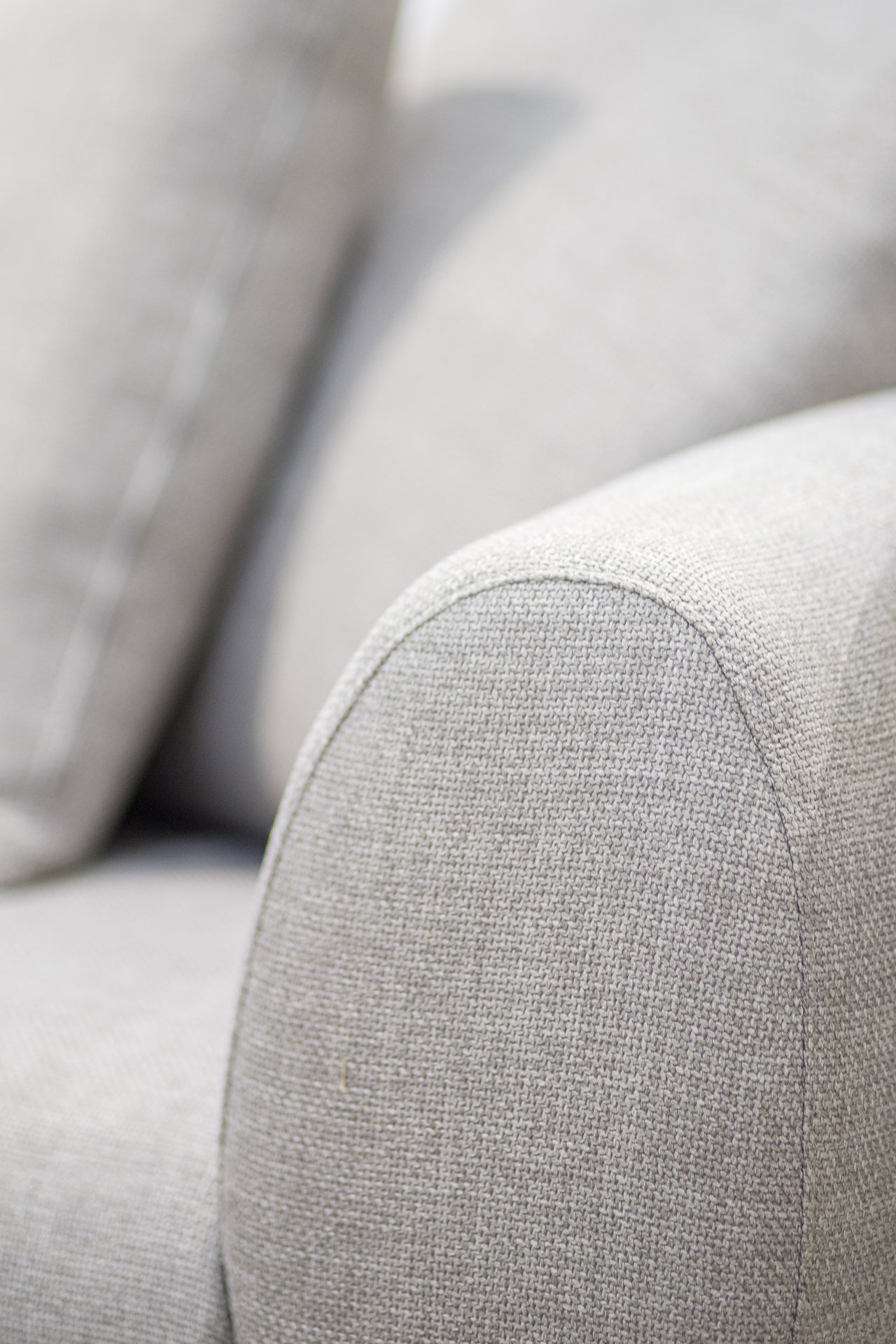 Close-up of a light gray sofa with visible texture