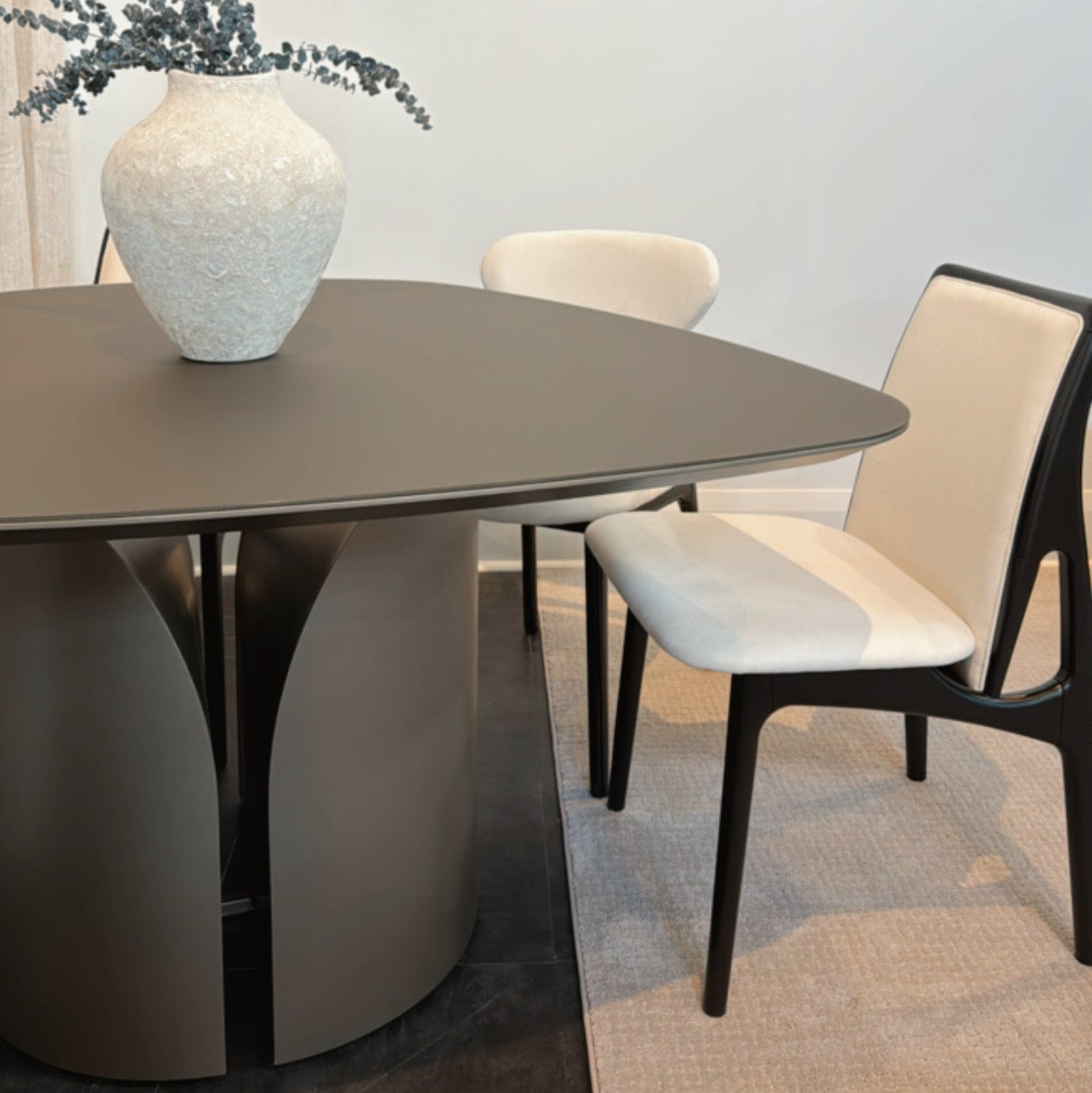 Dining table with a vase and chairs in a room setting