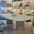 Load image into Gallery viewer, Modern dining room with a white oval table and blue chairs.