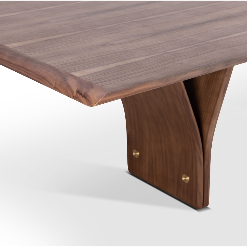 A rectangular dining table leg detail, with natural walnut wood finish and a distinctive Y-shaped design in its legs, set against a white background.