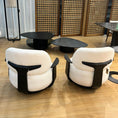 Load image into Gallery viewer, Two modern chairs with white cushions and black frames on a wooden floor.