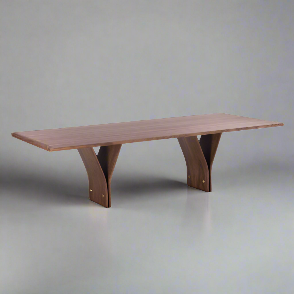A rectangular dining table with natural walnut wood finish and a distinctive Y-shaped design in its legs, set against a graybackground.