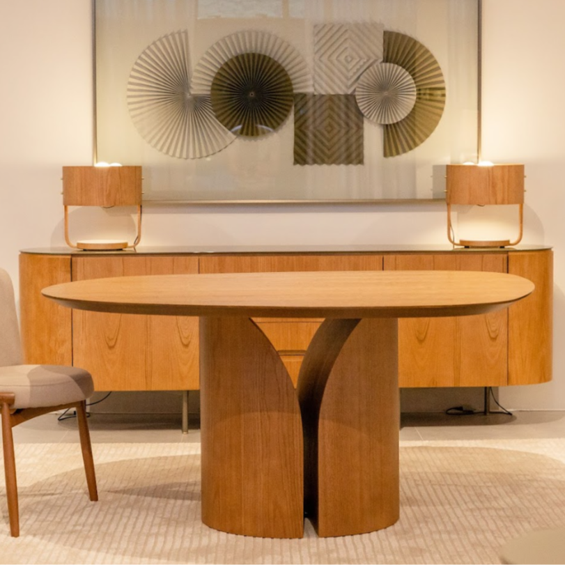 Dining room with wooden table and chairs, and a decorative wall piece.