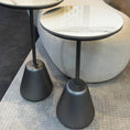Load image into Gallery viewer, Two modern side tables with marble tops and black bases in a living room setting.