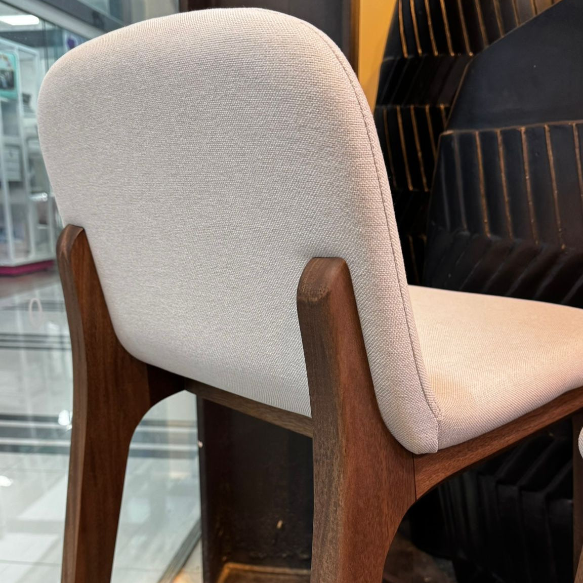 Bar stool with white cushioned seat and backrest in a modern setting