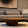 Charger l'image dans la visionneuse de la galerie, Wooden coffee table in front of a gray sofa with a textured wall in the background