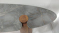 Load image into Gallery viewer, A modern sculptural table featuring a gray marble top with natural veining and a round wooden pedestal base.
