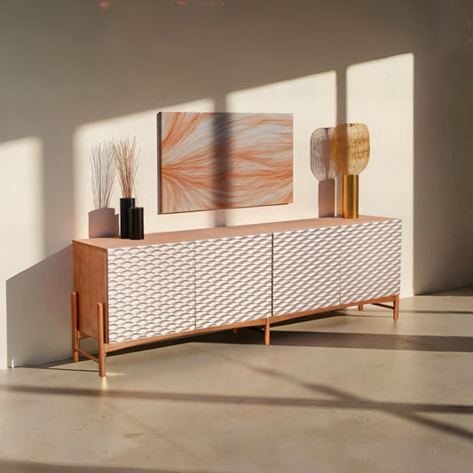 A sideboard with a smooth, lacquered finish with four doors, set on a white light backround.