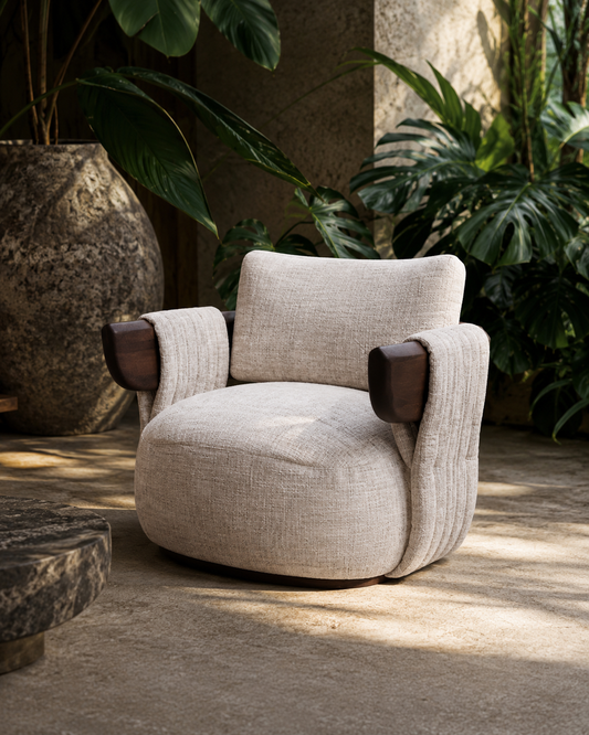 Beige armchair with brown armrests in a room with plants and stone walls