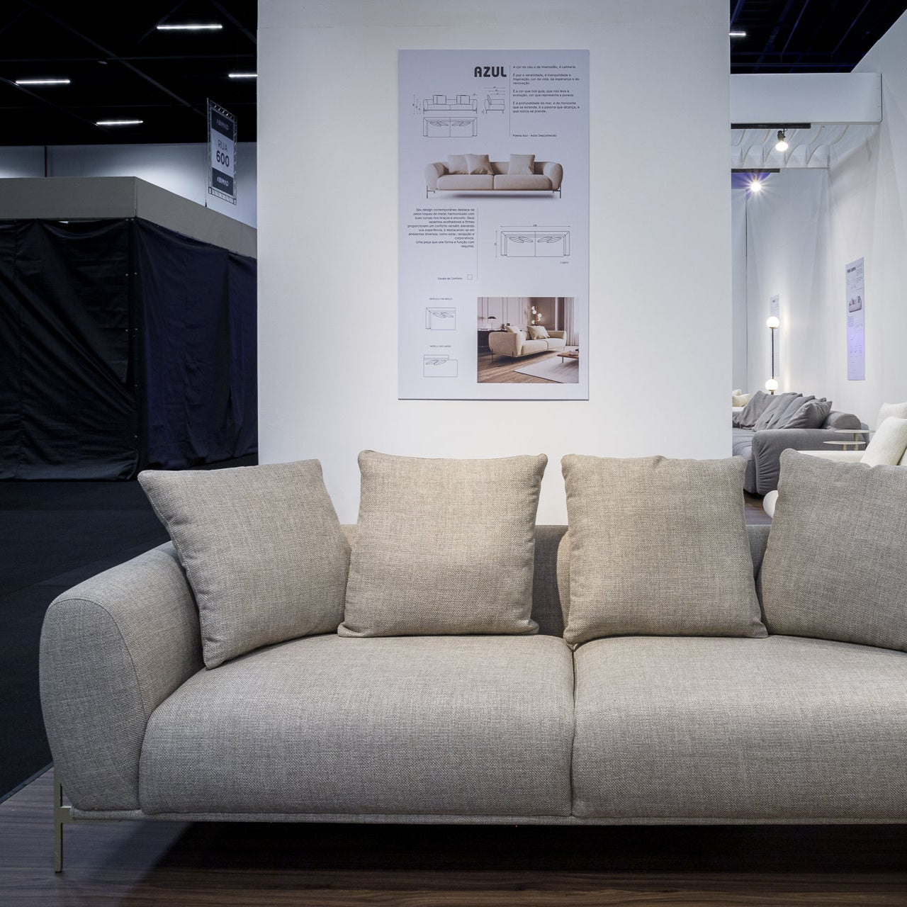 Gray sofa in a showroom with posters on the wall.