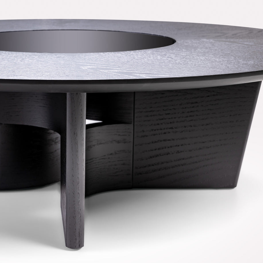 Round black coffee table with a textured surface on a white background