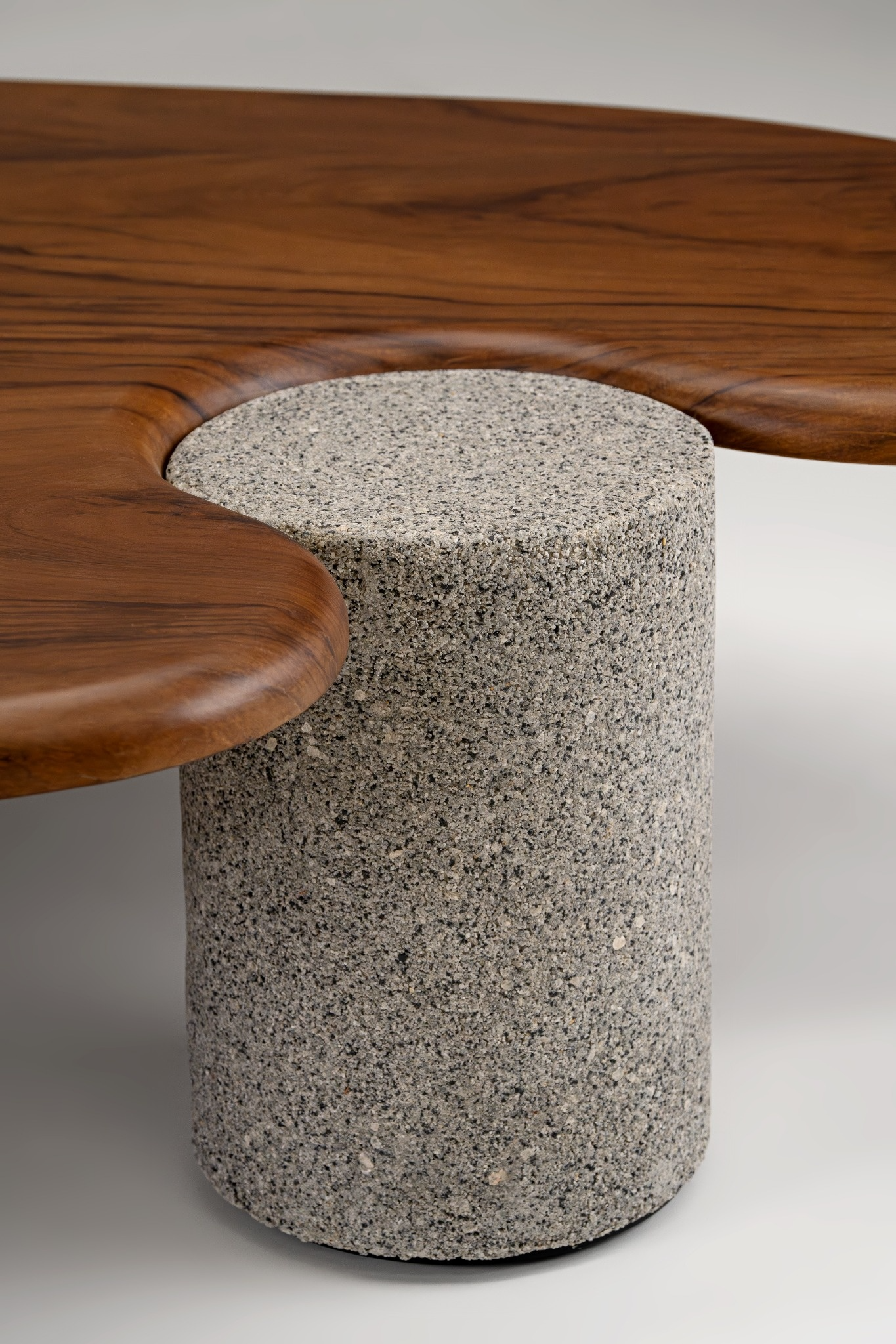 Wooden coffee table with a concrete cylindrical stool on a neutral background