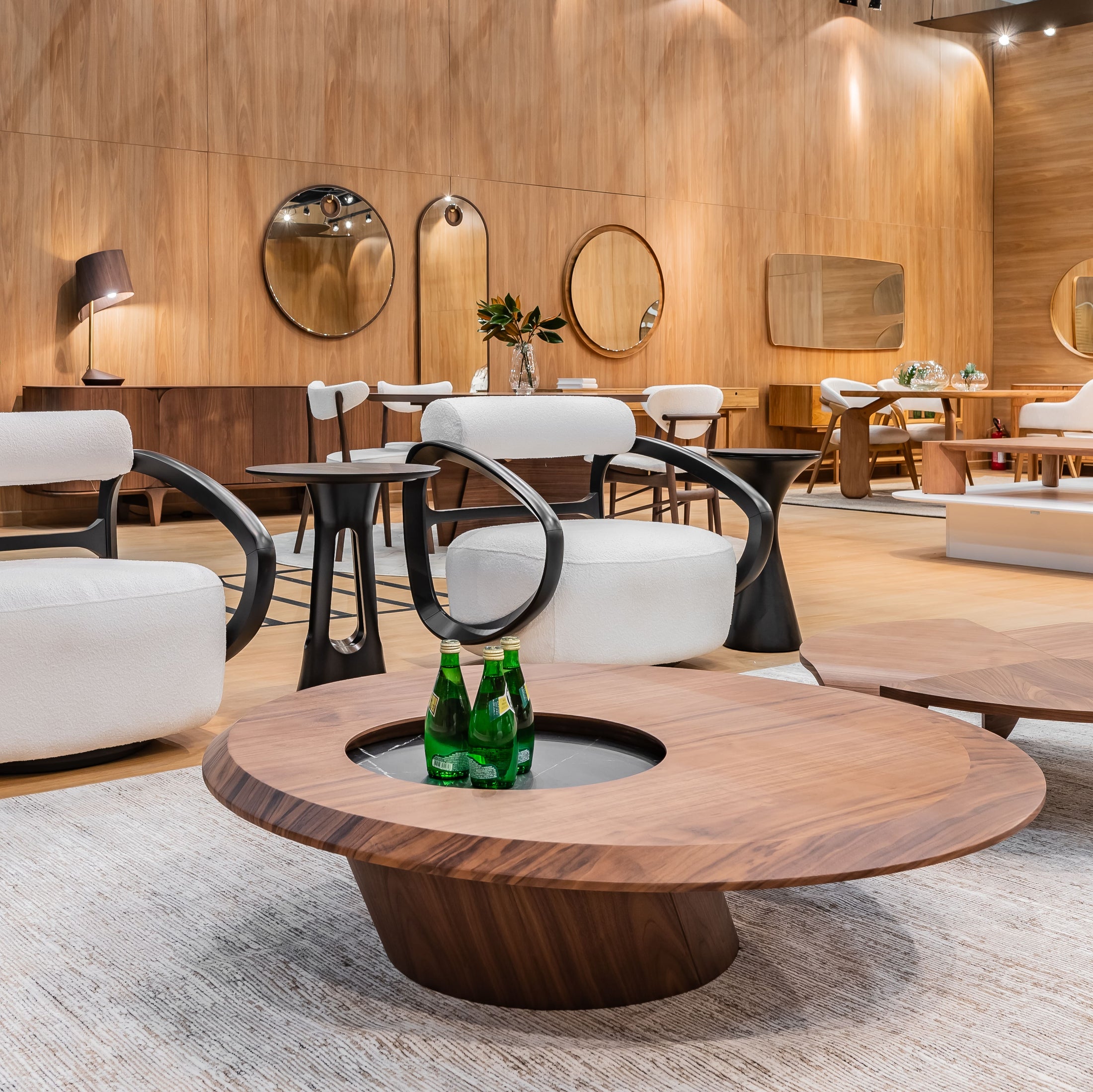 Modern indoor setting with white chairs, wooden tables, and decorative elements.