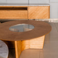 Load image into Gallery viewer, Wooden coffee table with a glass top in a modern interior setting.
