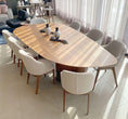Load image into Gallery viewer, A contemporary design dining table with a smooth, oval-shaped natural oak wood tabletop, supported by two cylindrical legs.
