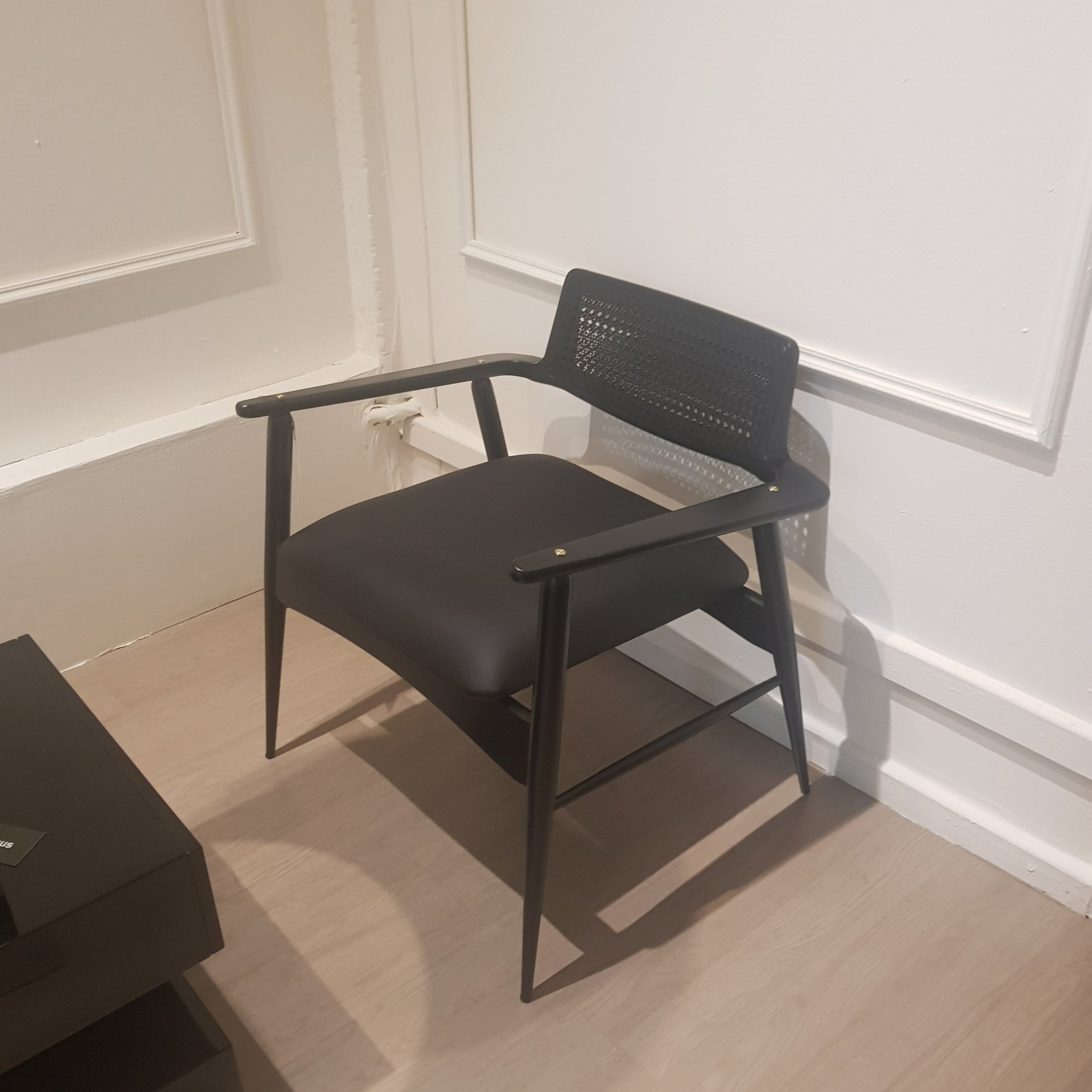 Black wood chair against a white wall