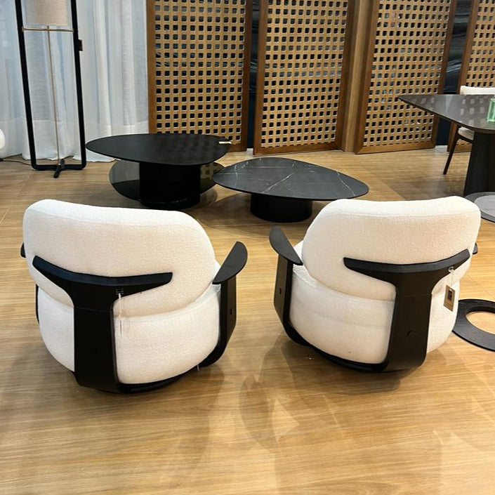 Two modern chairs with white cushions and black frames on a wooden floor.