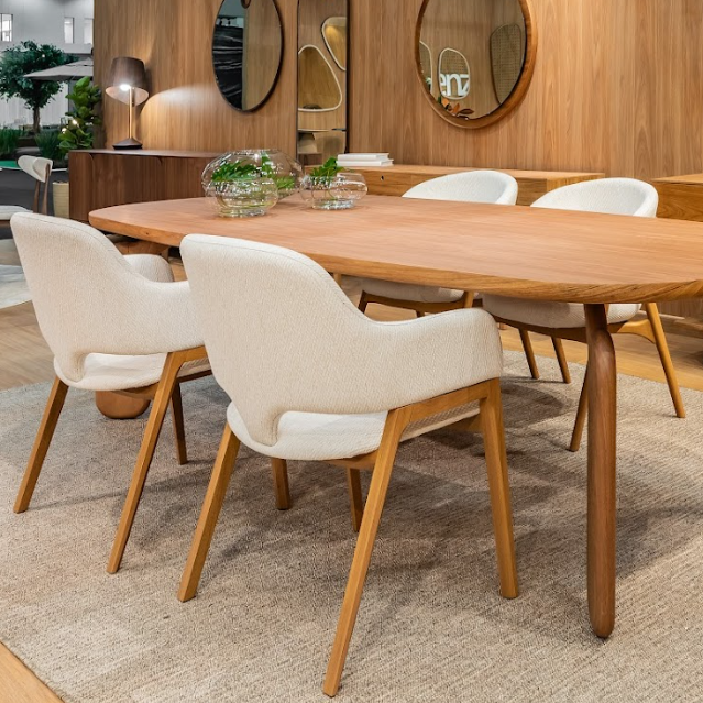 Dining room with wooden table and beige chairs in a modern interior setting.