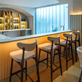 Load image into Gallery viewer, Modern bar area with stools and a well-lit background
