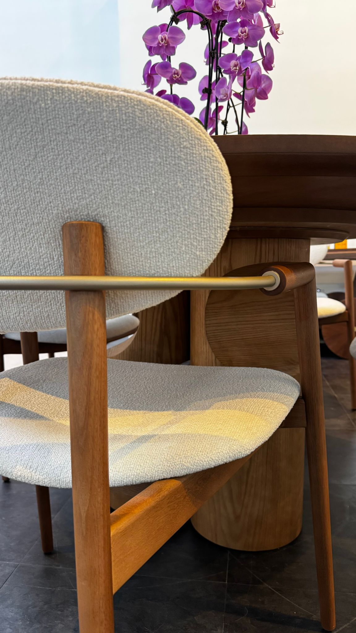 Chair with wooden frame and gray cushioned seat and backrest in a room setting.