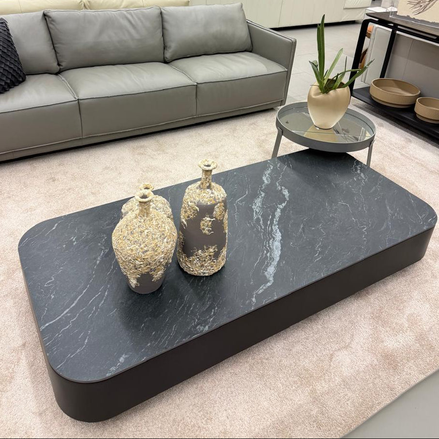 Modern living room with gray sofa, marble coffee table, and decorative items.