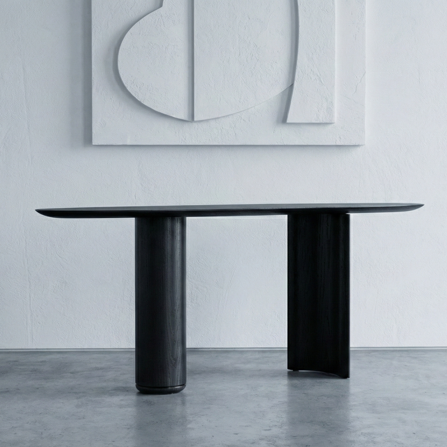 Modern black dining table in a minimalistic room with abstract art on the wall.