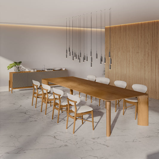 Modern dining area with a long wooden table and chairs in a minimalistic setting.