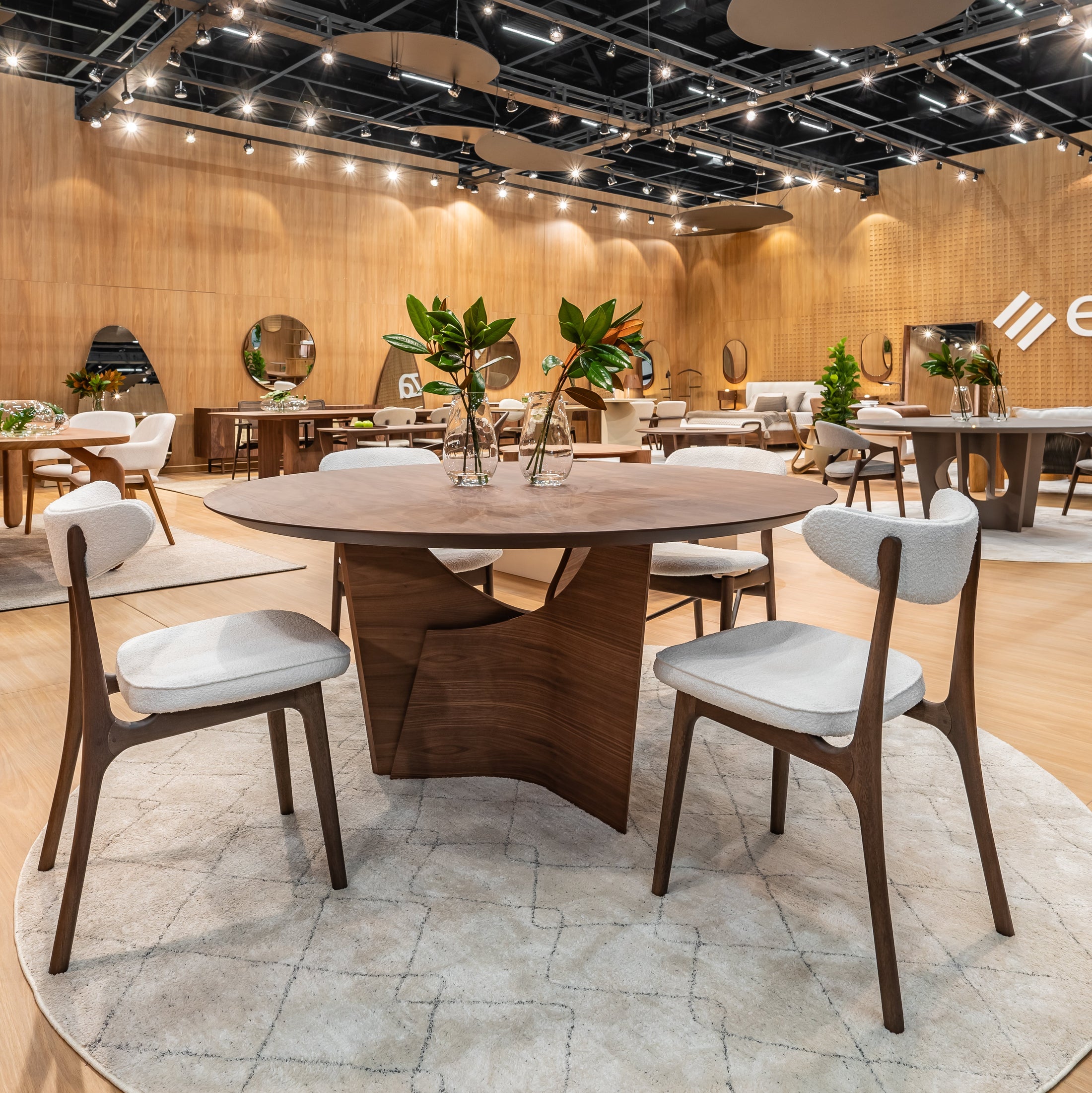 Modern dining area with wooden tables and chairs in a showroom setting.