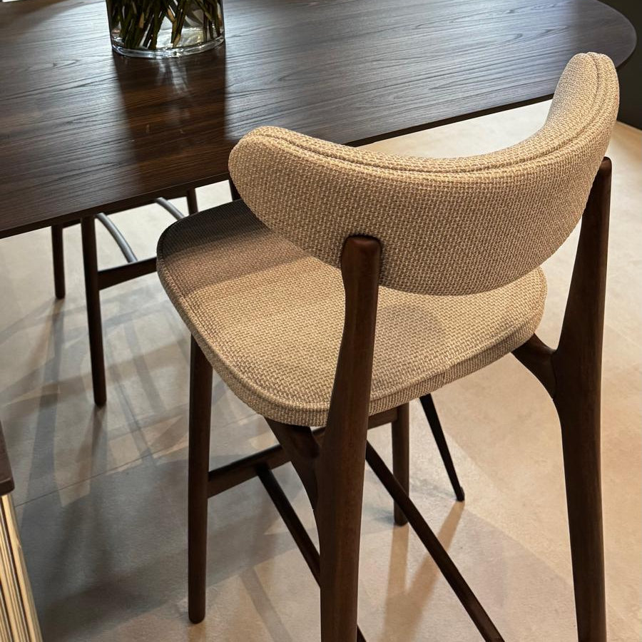 Dining table with a vase of yellow roses and a chair in a modern interior setting.